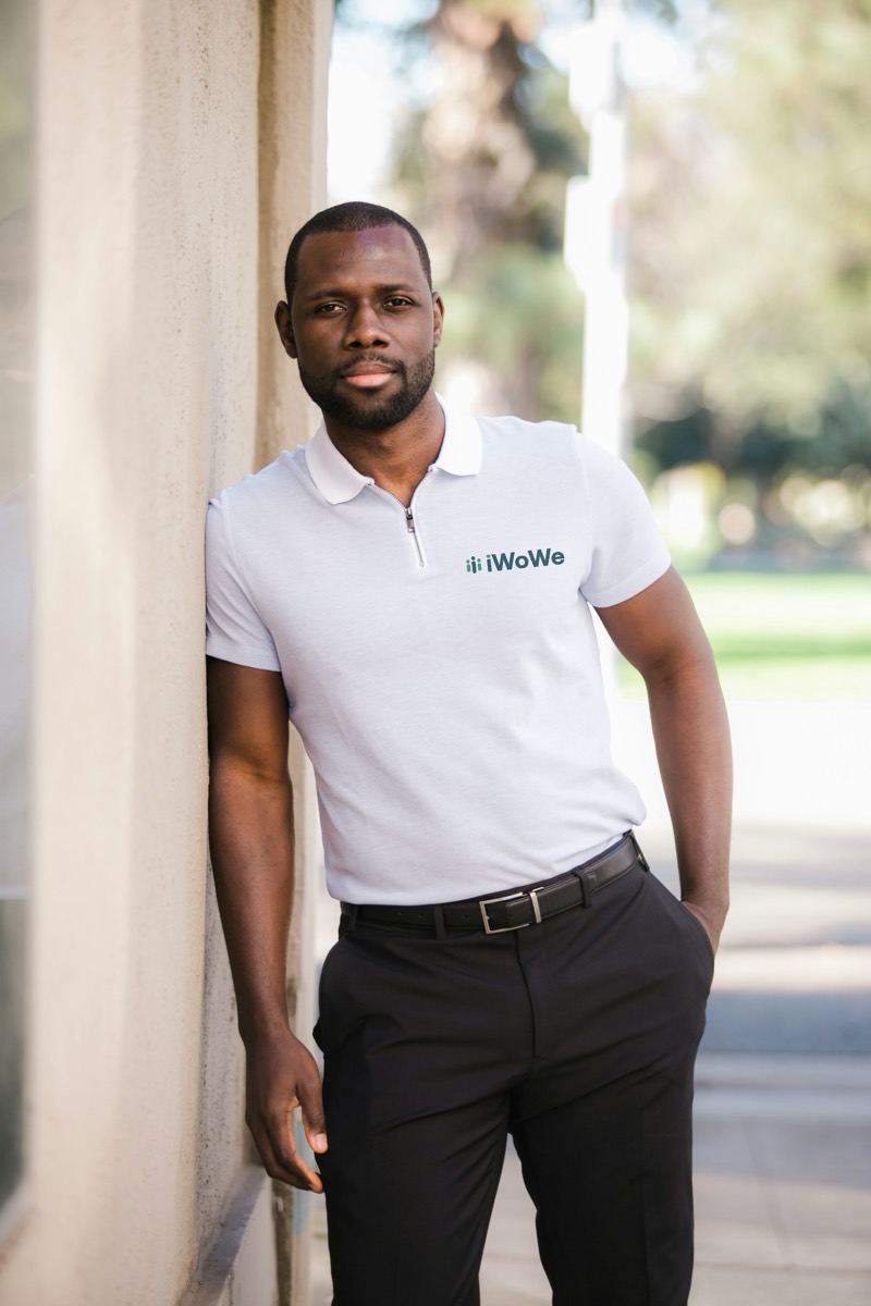 A man wearing a white polo shirt with the iWoWe logo